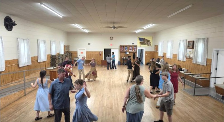 Couples swing dancing across the hall
