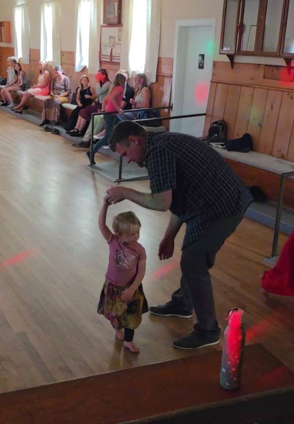 An adult dancing with a young child